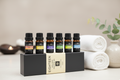 Lura Pure Essential Oils set in a gift box next to white towels and spa stones, highlighting the premium wellness experience.